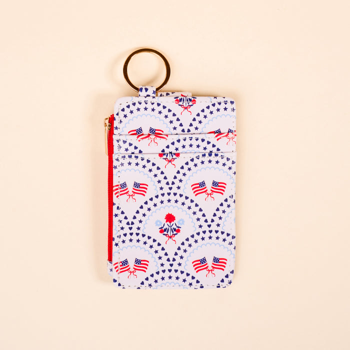 The Darling Effect's All-American Darling Keychain Wallet features a zippered pouch and keyring, decorated with American flag patterns and patriotic symbolsβideal as a slim wallet or card holder for daily use.