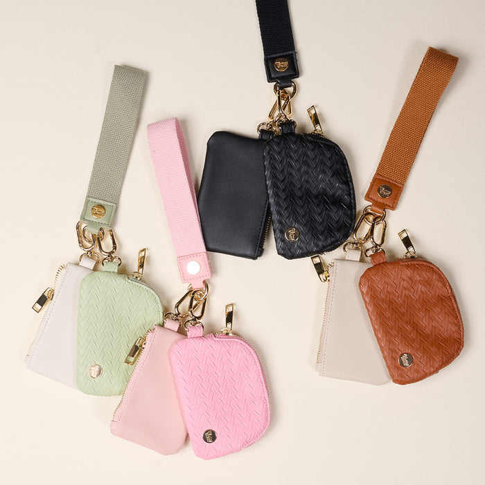 The Darling Effect’s Black Dynamic Duo Pouch Luxe Wristlet features two pouches—a woven-texture and a smooth, gold hardware pouch—on a wristlet strap, perfect for hands-free elegance.