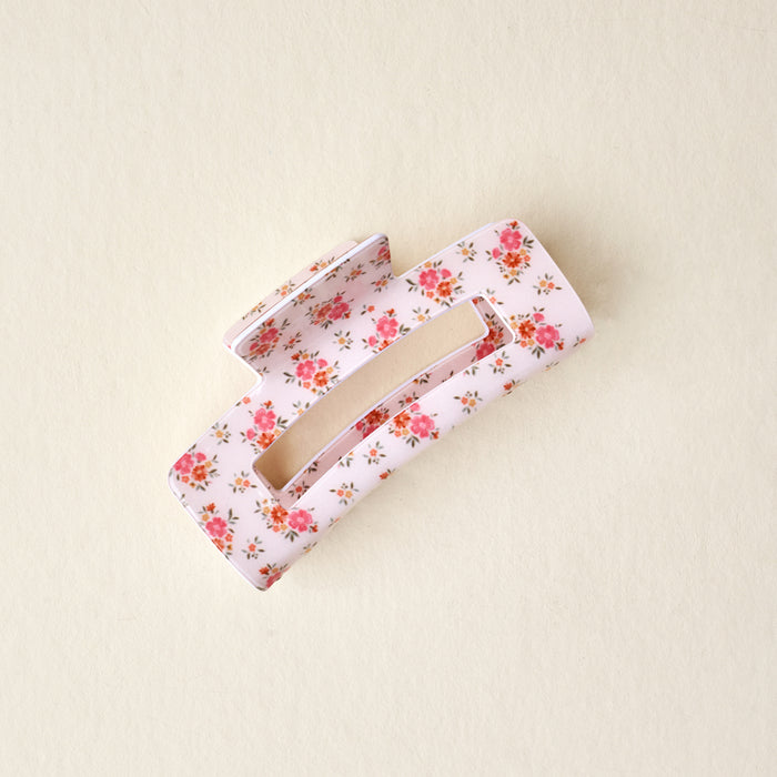 The Endless Daydream Cream Claw Clip by the-darling-effect features a pink floral print and strong hold, shown on a beige background.