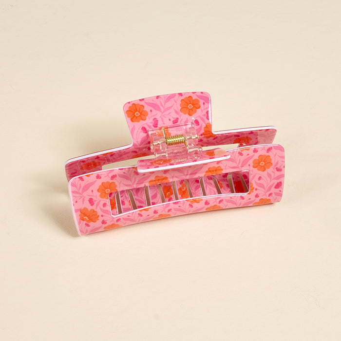 The Darling Effectβs Poppin' Petals Hot Pink Claw Clip features a pink base, orange floral print, and cream accentsβdelivering a strong hold and bold style as an eye-catching hair accessory.