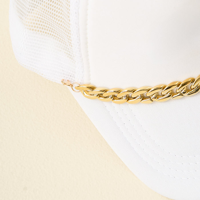 Close-up of a white mesh trucker hat with a curved brim, featuring The Darling Effect's Acrylic Link Gold Trucker Hat Chain across the front against a light cream background.