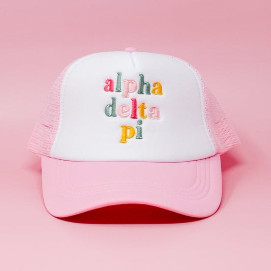 The Darling Effect Alpha Delta Pi Pink Trucker Hat features pink and white embroidery with colorful "alpha delta pi" stitching—ideal as a cute gift or everyday sorority accessory.