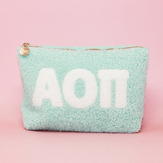 The Darling Effect Alpha Omicron Pi Aqua Teddy Letter Pouch features white sherpa letters, a gold zipper with a charm, and is perfect as a cute sorority or teddy pouch.
