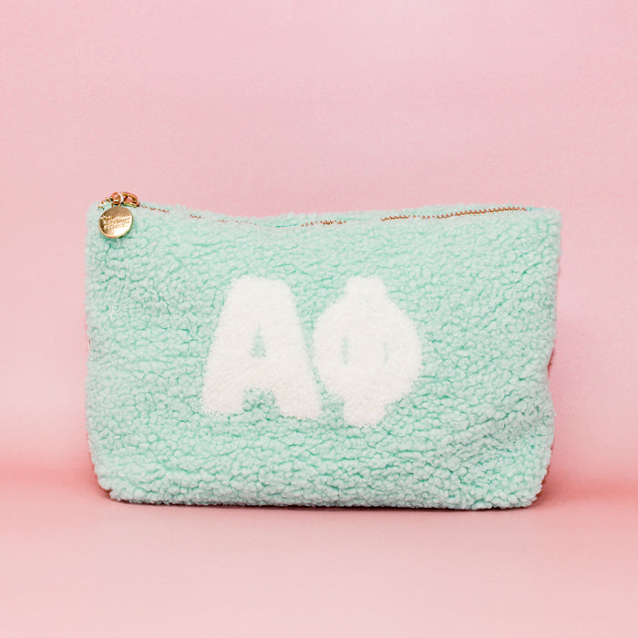 The Darling Effect's Alpha Phi Aqua Teddy Letter Pouch features white Greek letters on a mint green fuzzy background—ideal as a cute sorority accessory or stylish carry-on.