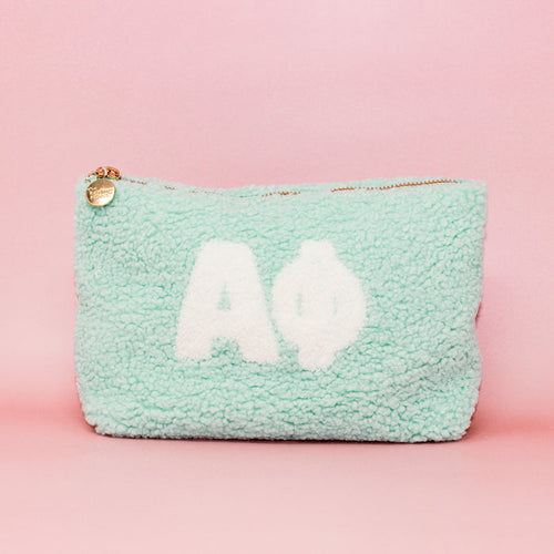 The Darling Effect's Alpha Phi Aqua Teddy Letter Pouch features white Greek letters on a mint green fuzzy background—ideal as a cute sorority accessory or stylish carry-on.