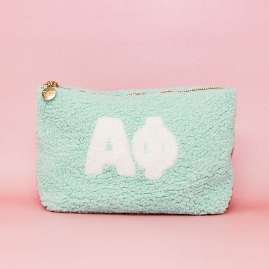 The Darling Effect's Alpha Phi Aqua Teddy Letter Pouch features white Greek letters on a mint green fuzzy background—ideal as a cute sorority accessory or stylish carry-on.