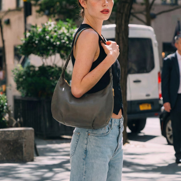 woman holding Aoyama 2 leather in green on a city street