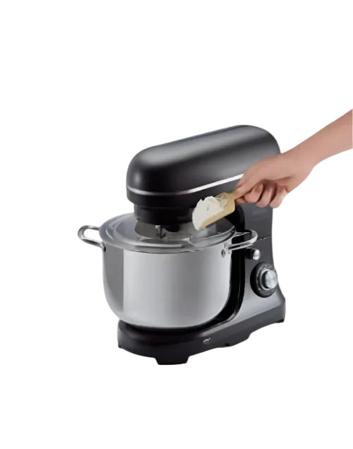 Black stand mixer with a person adding ingredients on a white background