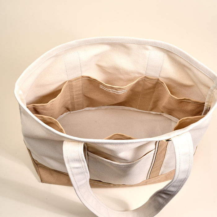 A top view of The Darling Effect's Beige The Signature Canvas Tote Bag, featuring durable handles and multiple interior pockets, perfect for everyday use, set against a light background.