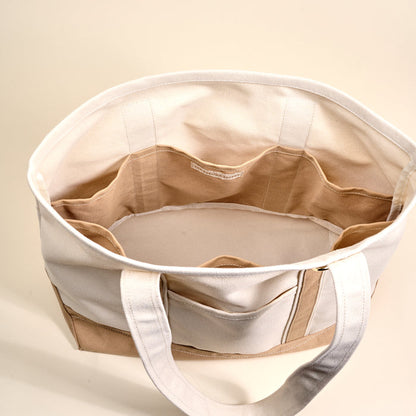 A top view of The Darling Effect's Beige The Signature Canvas Tote Bag, featuring durable handles and multiple interior pockets, perfect for everyday use, set against a light background.