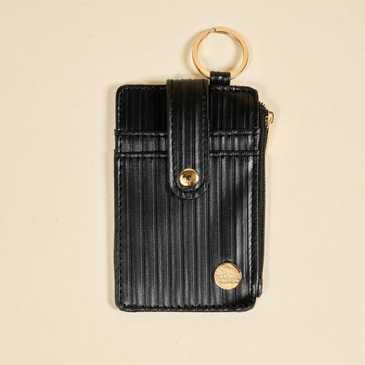 The Darling Effect Black Ripple Ridge Keychain Wallet features a black vertical-striped design, snap closure, gold zipper, and gold keyring—perfect as a stylish zippered coin holder or compact wallet.