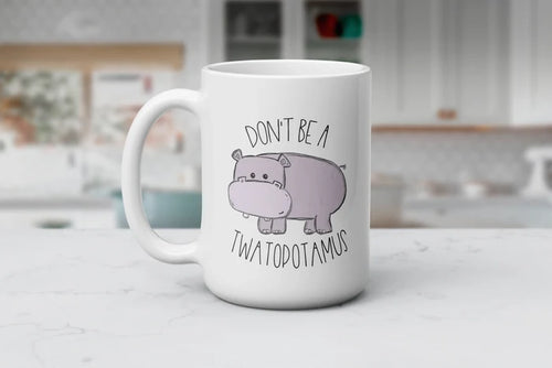 Chubby Cheeks & Petty Streaks white ceramic coffee mug featuring a cute purple hippo and the funny phrase “Don't Be a Twatopotamus,” available in 11 oz and 15 oz sizes.