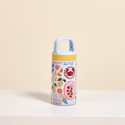 The Darling Effect’s Ciao Bella 6 oz Lil' Bitty Bottle, featuring a light blue handle, yellow lid, and bold fruit and abstract designs over beige, is the ideal stylish hydration companion for travel and adventures.
