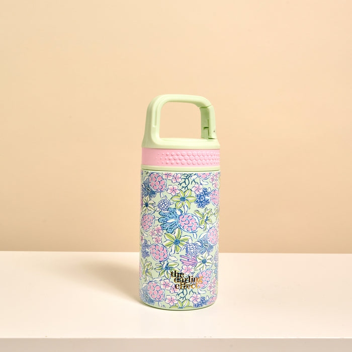 The Darling Effect’s Coastal Cove 6 oz Lil' Bitty Bottle features a light green floral design, pink accents, and a mint green handle—perfect for staying hydrated while you travel.