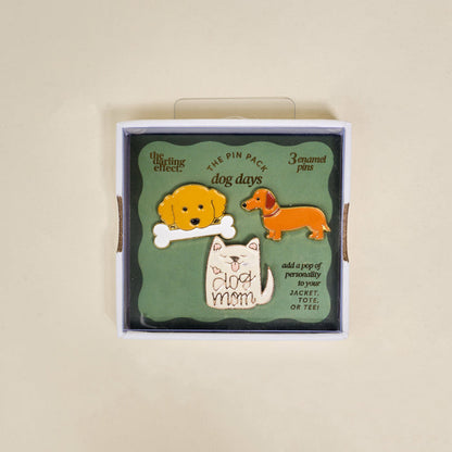 The Darling Effect Dog Days The Pin Pack includes three collectible pins—a yellow dog with a bone, a brown dachshund, and a white cat with "dog mom" text—perfect playful accessories for your jacket, tote, or tee.