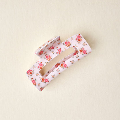 The Endless Daydream Cream Claw Clip by the-darling-effect features a pink floral print and strong hold, shown on a beige background.