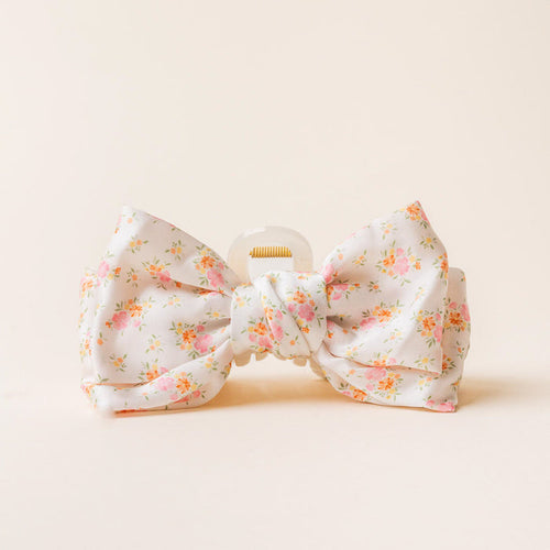 The Endless Daydream Cream Satin Bow Claw Clip by the-darling-effect features a large white satin bow with pink and orange floral details and a knotted center—an elegant accessory for any occasion.