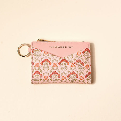 The Darling Effect Everbloom Dusty Rose Luxe Pocket Wallet features a floral criss-cross design, gold zipper, keychain, vegan leather, and “THE DARLING EFFECT” in gold on the top pink section.