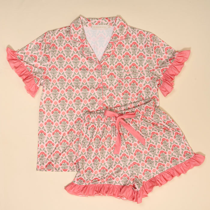 The Darling Effect's Everbloom Dusty Rose Slumber Party Pajama Shorts Set features a pink floral design, ultra-soft fabric, ruffled sleeves, and a collared button-up top with relaxed fit drawstring shorts for cozy comfort.