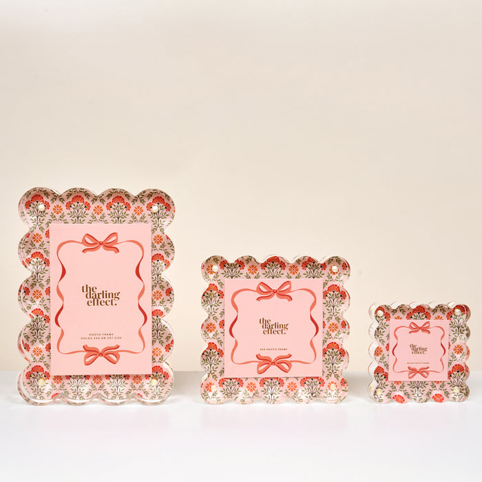 Three Everbloom Dusty Rose Square Scalloped Acrylic Picture Frames by The Darling Effect, in small, medium, and large sizes, feature pink floral patterns, scalloped edges, and a center card reading "the darling effect.