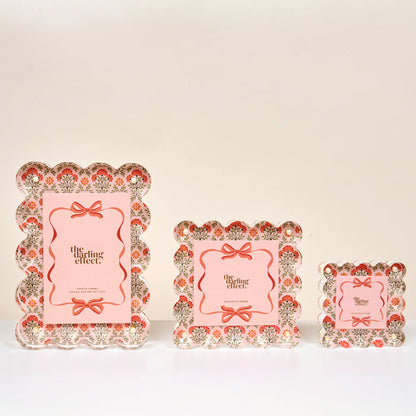 Three Everbloom Dusty Rose Square Scalloped Acrylic Picture Frames by The Darling Effect, in small, medium, and large sizes, feature pink floral patterns, scalloped edges, and a center card reading "the darling effect.
