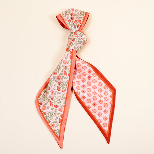The Darling Effect's Everbloom Dusty Rose Twirl & Tie Scarf Accessory features a pink and red floral pattern on one side, red daisies on the other, and easily ties for boutique charm. Perfect to elevate any outfit.