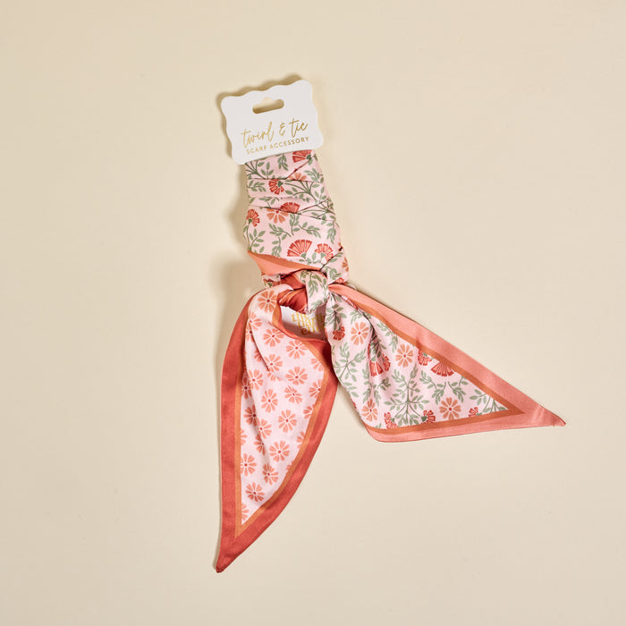 The Darling Effect Everbloom Dusty Rose Twirl & Tie Scarf Accessory features pink and green floral prints, packaged for gifting, adding boutique charm and versatile style to any outfit.