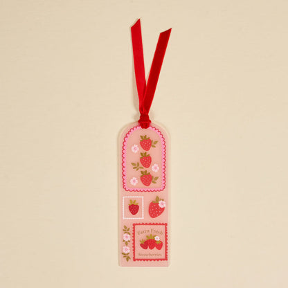 The Darling Effect's Farm Fresh Strawberries Acrylic Bookmark features strawberries, flowers, and the text "Farm Fresh Strawberries" on a cream background with a red ribbon—an adorable gift for book lovers.