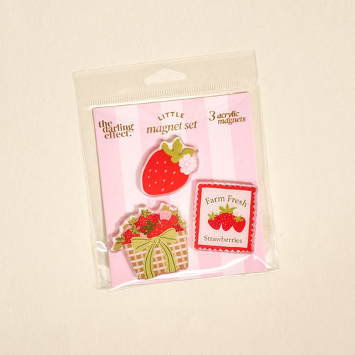 The Darling Effect's Farm Fresh Strawberries Little Magnet Set includes three decorative acrylic fridge magnets with strawberry-themed designs on a pink and white striped background.