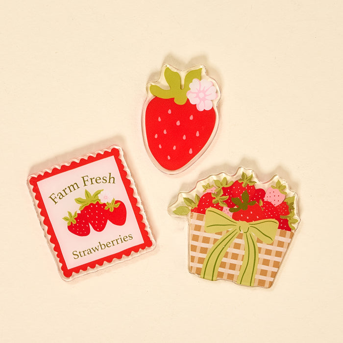 The Darling Effect's Farm Fresh Strawberries Little Magnet Set includes three accents: a single strawberry, a basket of strawberries with a green bow, and a square magnet that reads "Farm Fresh Strawberries" with two illustrated berries.