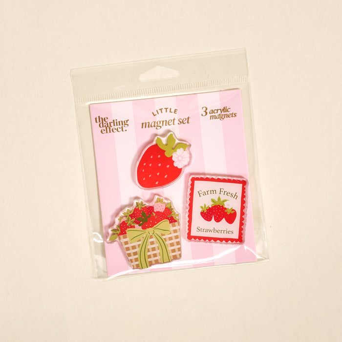 The Darling Effect’s Farm Fresh Strawberries Little Magnet Set features three acrylic magnets—a large strawberry, a strawberry basket, and a “Farm Fresh Strawberries” sign—perfect for adding charm to your fridge.
