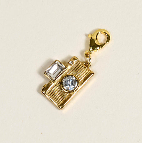 The Darling Effect’s Film Camera Jewelry Charm Gold features a lobster clasp and two clear gemstones—one square, one round—set against a light background, perfect for personalizing your jewelry or charm bar collection.