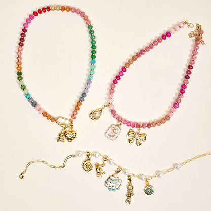 Three colorful beaded necklaces with gold clasps and various charms—including The Darling Effect's Film Camera Jewelry Charm Gold—are displayed on a light beige background, ideal for creating your own charm bar or custom jewelry look.