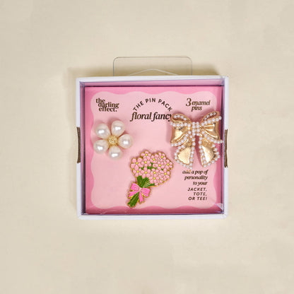 The Darling Effect's Floral Fancy The Pin Pack features three collectible pins—a pearl flower, gold bow with pearl details, and pink bouquet—to add playful charm to your jacket, tote, or tee.