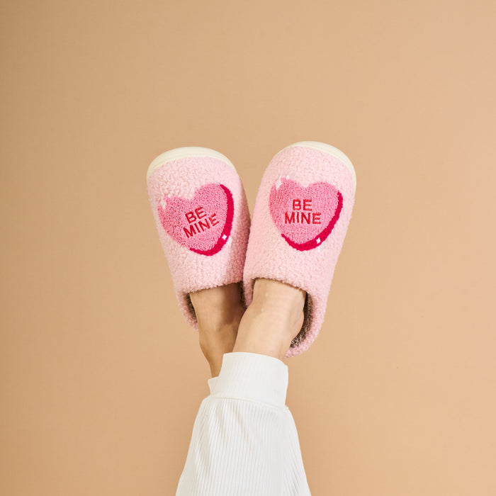 The Darling Effect Fuzzy Slippers-Be Mine feature a soft pink design with "BE MINE" hearts, perfect for cozy lounging.