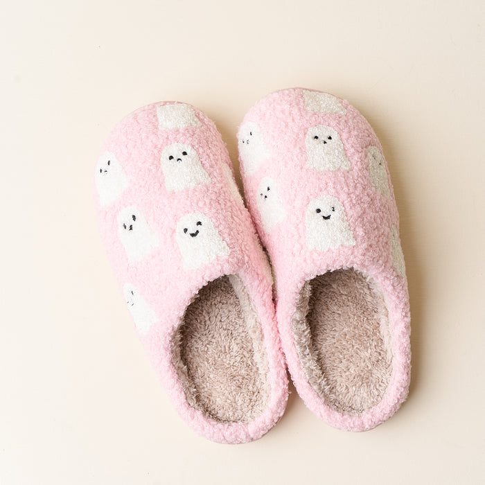 The Darling Effect’s Ghosts Fuzzy Slippers feature warm, fuzzy pink exteriors with cream linings and adorable white cartoon ghosts. These cozy, fall-themed slippers are shown side by side on a light beige background.