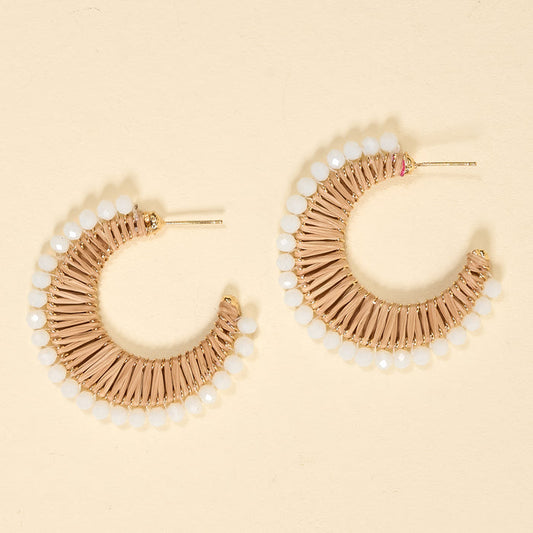 The Darling Effect’s Golden Sand It-Girl Earrings feature a crescent shape with beige woven thread and white beads on the edge—lightweight, perfect for daily wear, shown on a light beige background.