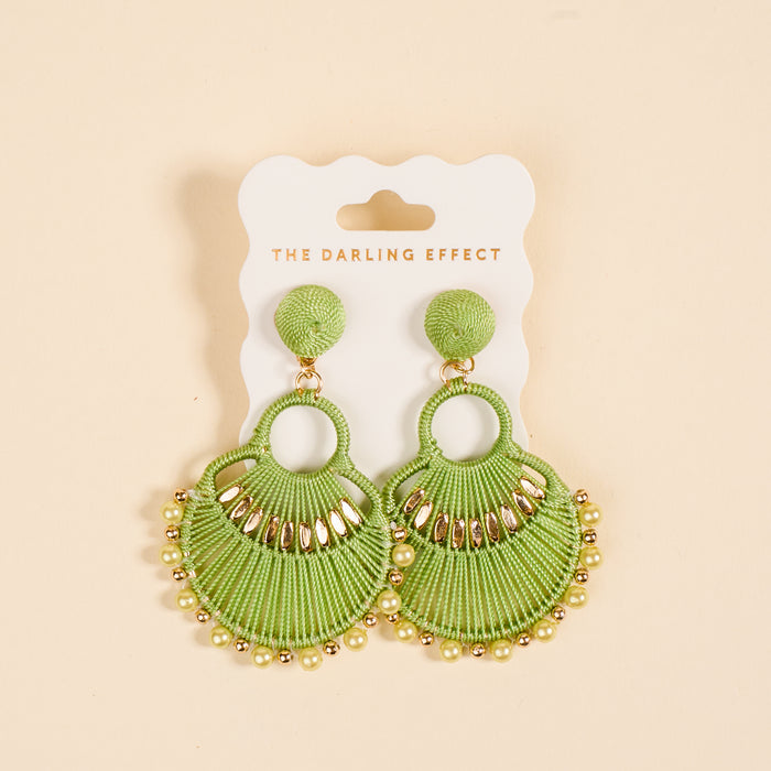 The Green Paloma Drop Earrings by The Darling Effect feature green fan shapes with gold accents and beads, perfect for daily wear, shown on a branded card against a light beige background.
