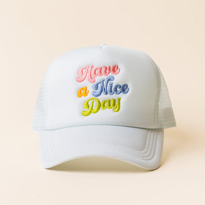 The Have a Nice Day Trucker Hat by the-darling-effect features light blue mesh and “Have a Nice Day” embroidered in pastel pink, orange, blue, and yellow—an ideal choice for trendy hat lovers.