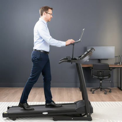 Man using a treadmill desk in an office setting while walking on treadmill.
