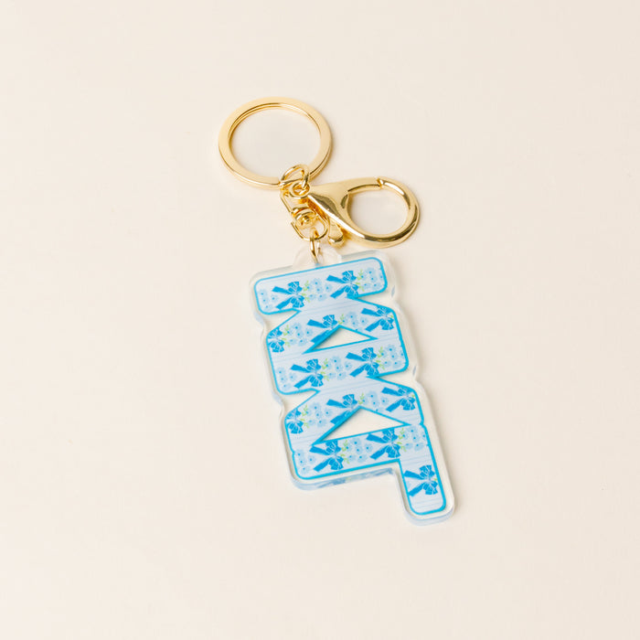 The Darling Effect's Kappa Kappa Gamma Oh So Fancy Letter Acrylic Keychain features gold hardware and a clear acrylic charm with blue floral Z Z A lettering—perfect for gifting to your sorority sisters.