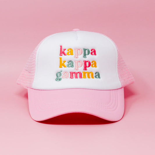 The Darling Effect's Kappa Kappa Gamma Pink Trucker Hat features colorful embroidered letters on pink and white—displayed on a solid pink background, it’s the perfect sisterhood gift for your closest friends.