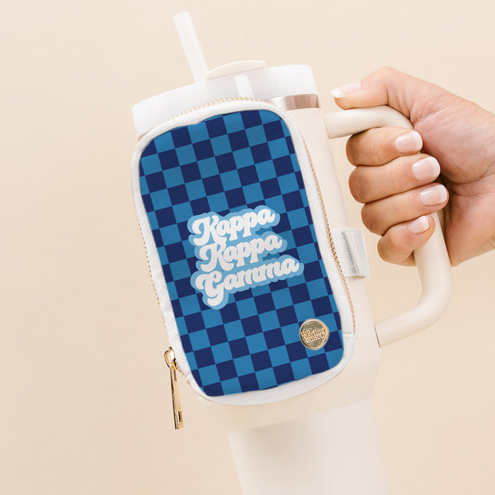 A hand holds The Darling Effect’s Kappa Kappa Gamma Tumbler Fanny Pack—a large white tumbler with a water-resistant blue checkered pouch, featuring “Kappa Kappa Gamma” in white script and a gold zipper with round gold emblem.
