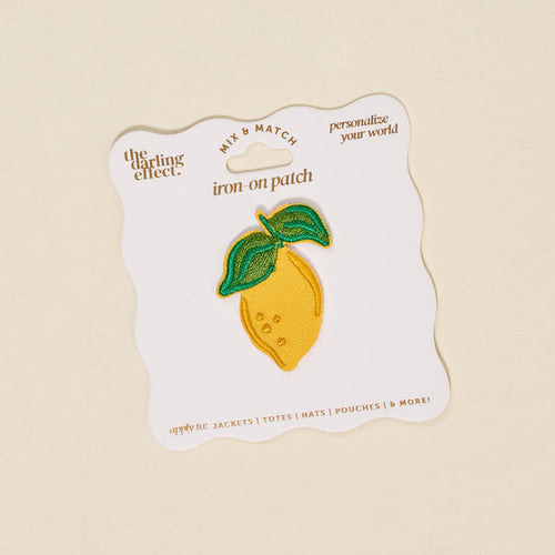 The Darling Effect’s Lemon Mix & Match Iron-On Patch features a yellow lemon with green leaves on a white card. Customize jackets, totes, hats, and more with this fun patch!.