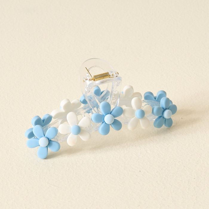 The Darling Effect’s Light Blue Game Day Daisy Claw Clip features clear plastic with blue and white daisy accents—ideal for showing off your school spirit or styling your hair on Game Day.