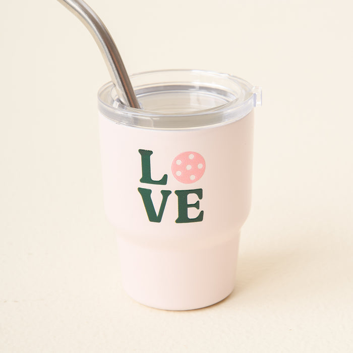The Love Pickleball 2 oz Tiny Tumbler by the-darling-effect is a light pink insulated cup with a clear lid and metal straw, featuring "LOVE" on the front. Compact and stylish, it's perfect for your favorite drinks on the go.
