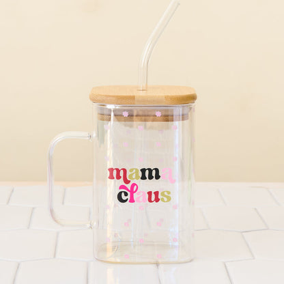 The Darling Effect’s Mama Claus Square Glass features a clear square design with a bamboo lid, straw, and cute pink flower accents.