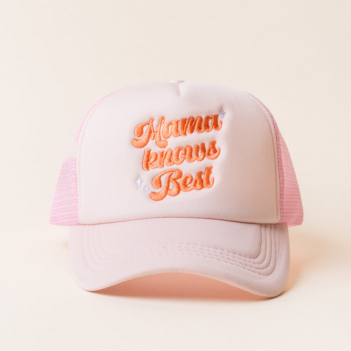 The Mama Knows Best Trucker Hat by the-darling-effect features light pink fabric, orange embroidered "Mama Knows Best" text, and small diamond accents.