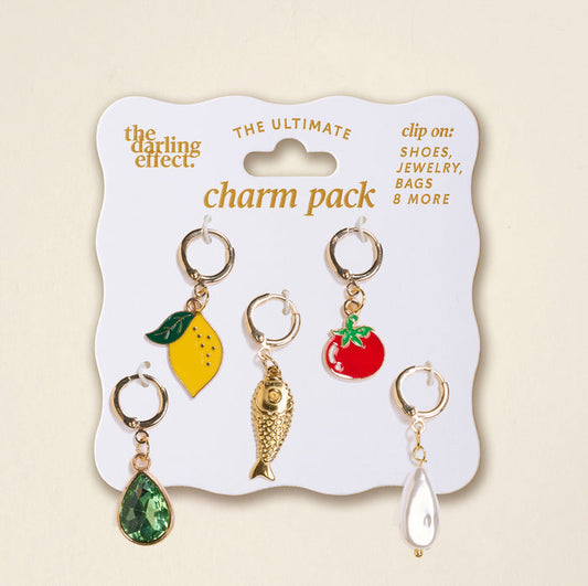 The Darling Effect’s Mediterranean Muse The Ultimate Charm Pack includes five gold keyring charms: yellow lemon with green leaf, red tomato, gold fish, green gem teardrop, and white pearl teardrop on a white card. Perfect for Scrunchie Charm Sets.