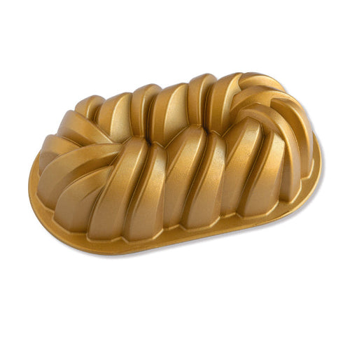 A gold-colored fluted loaf pan with a ribbed, pleated design, shown on a clean white background.